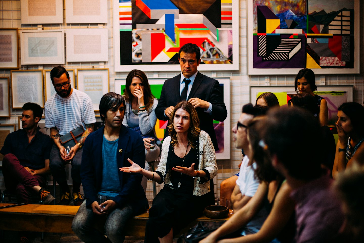 People in an art gallery discussing paintings.