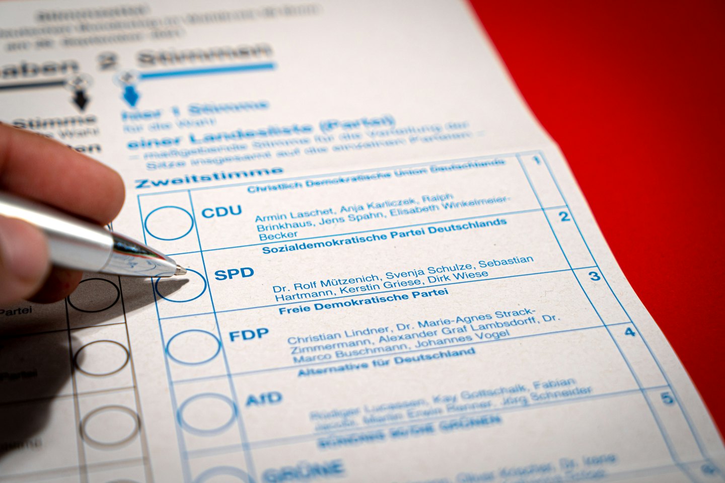 Hand holding pen over SPD vote on a ballot.