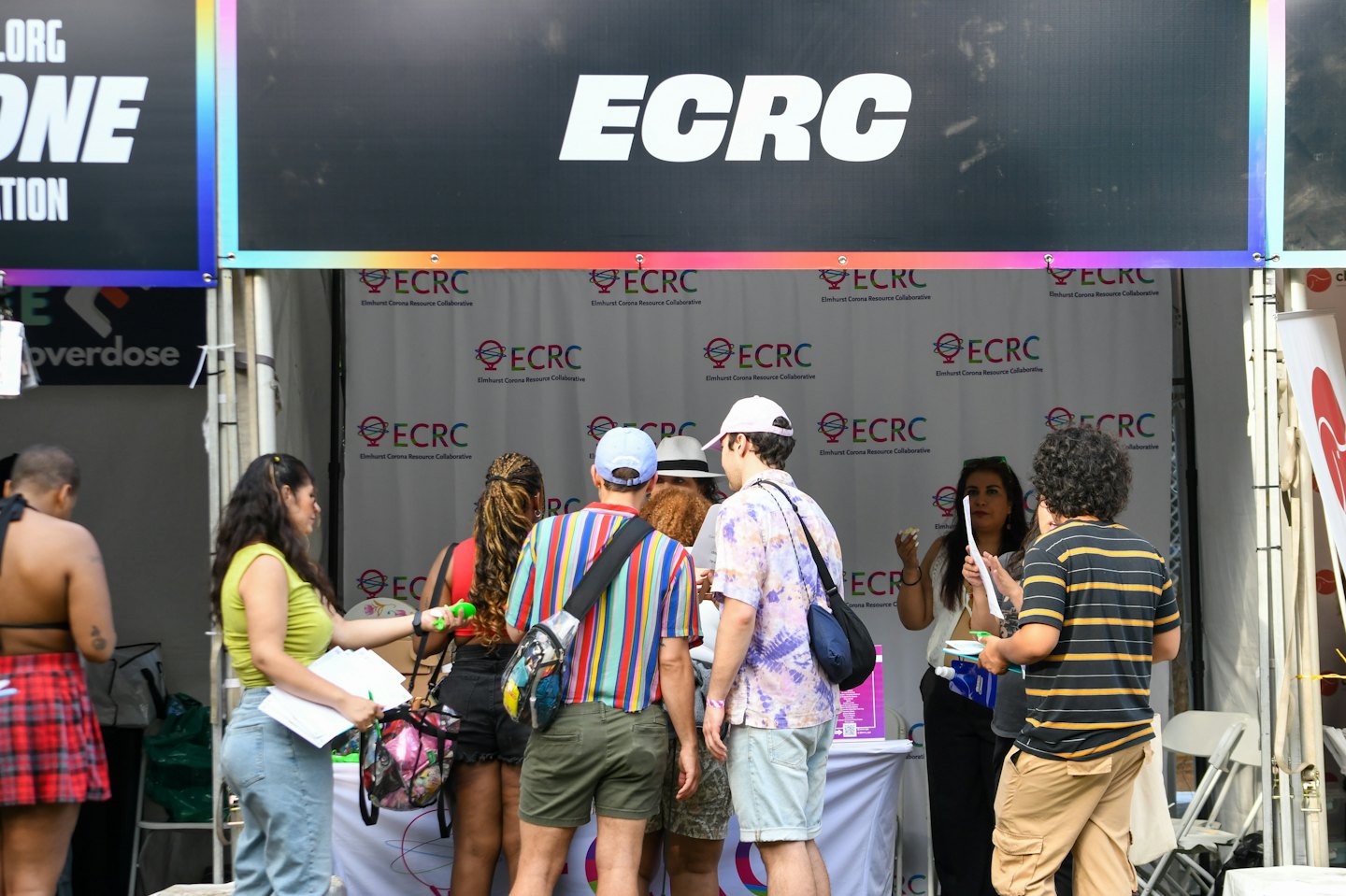 People gather around an ECRC information booth at an outdoor event.
