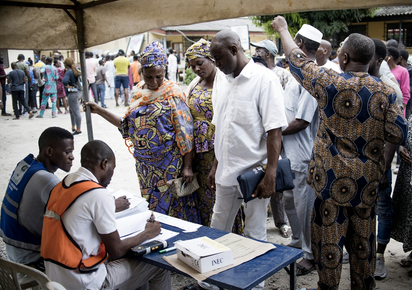People wait in line at an outdoor voter registration station.