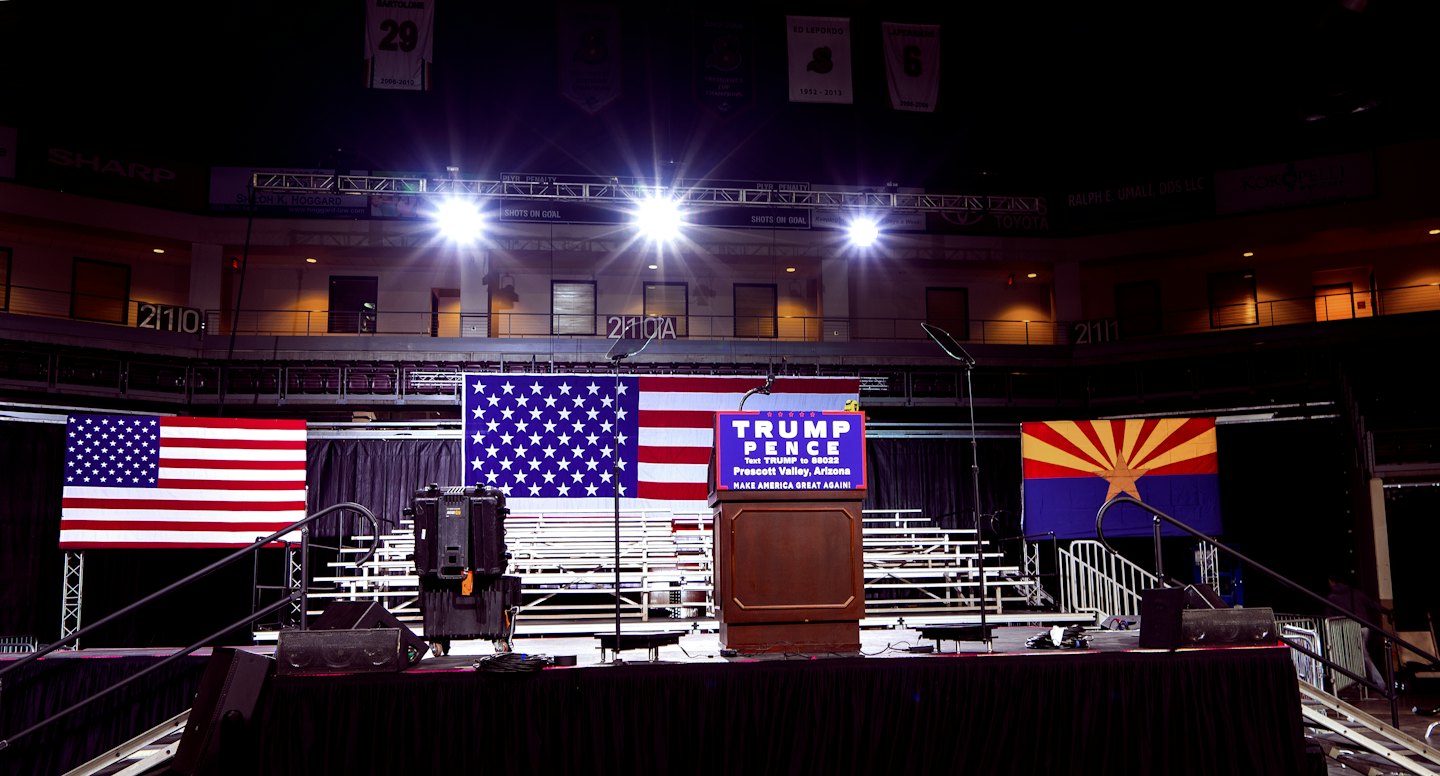 Empty stage with Trump Pence podium and American flags before a rally.